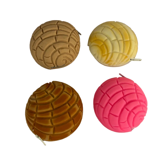 Four textured balls in gold, yellow, pink, and orange on a wooden surface.