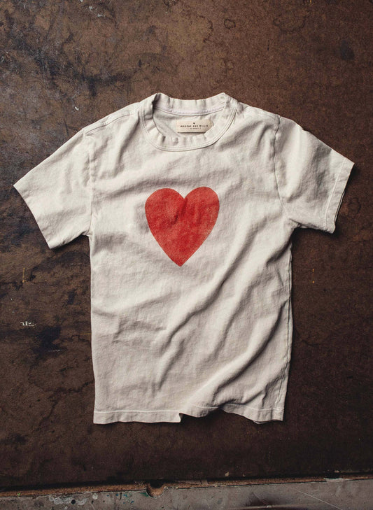 Flat lay on dark concrete showing full front with large red heart print and Imogene + Willie label