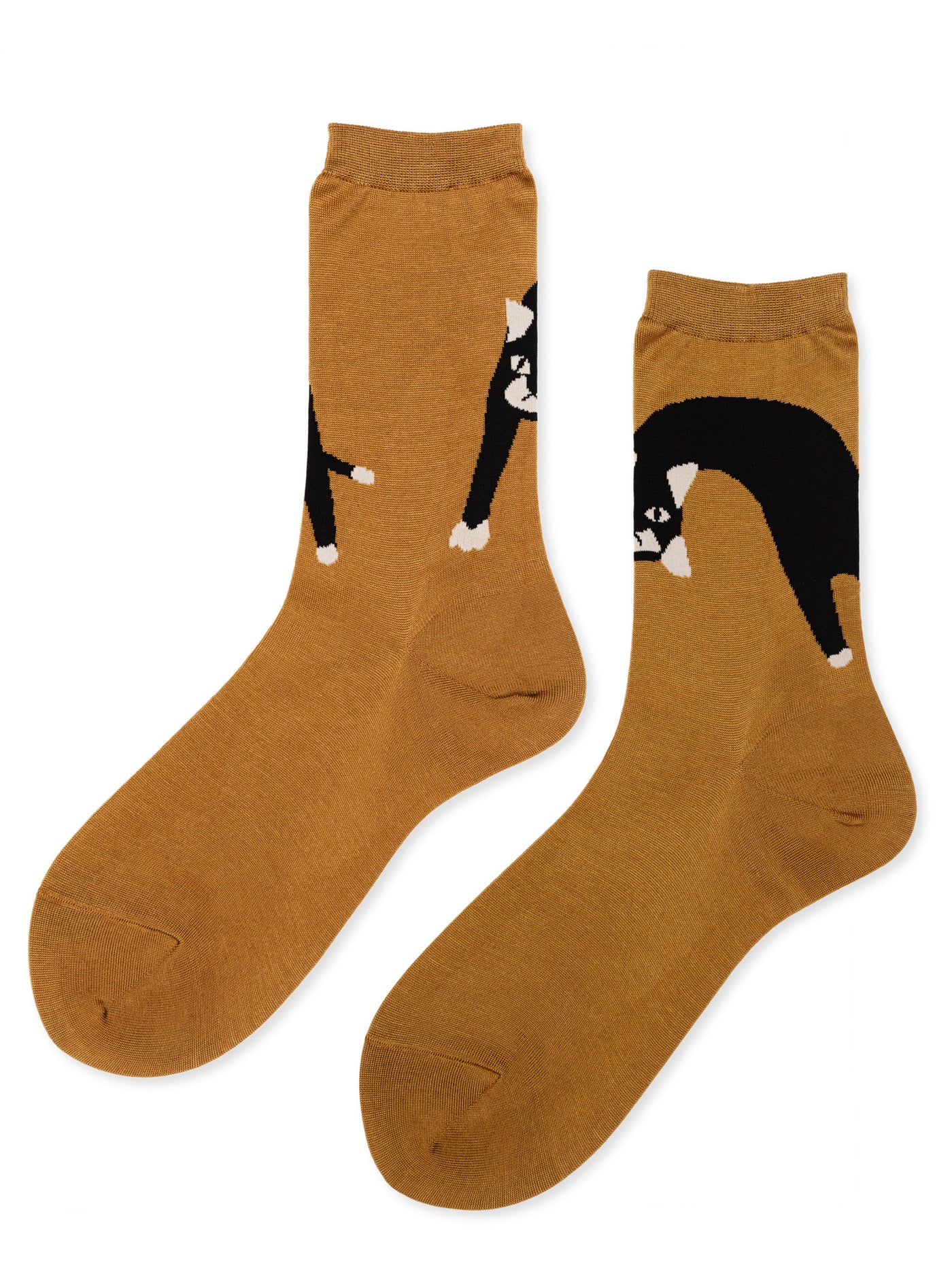 Pounce Crew socks in Camel — warm camel cotton crew with a black and white tuxedo cat motif spanning both feet, flat lay pair on white background
