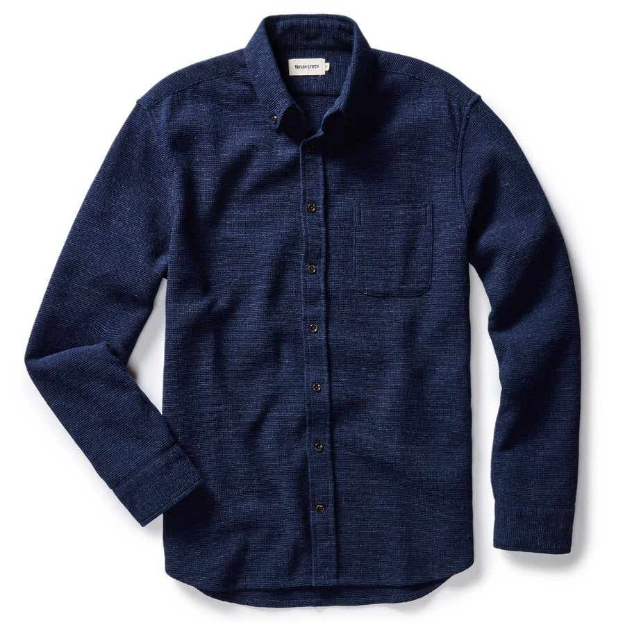 Flat lay of The Jack in Indigo Waffle by Taylor Stitch — a deep indigo organic cotton button-down shirt with waffle texture, button-down collar, chest pocket, and dark buttons, on a white background