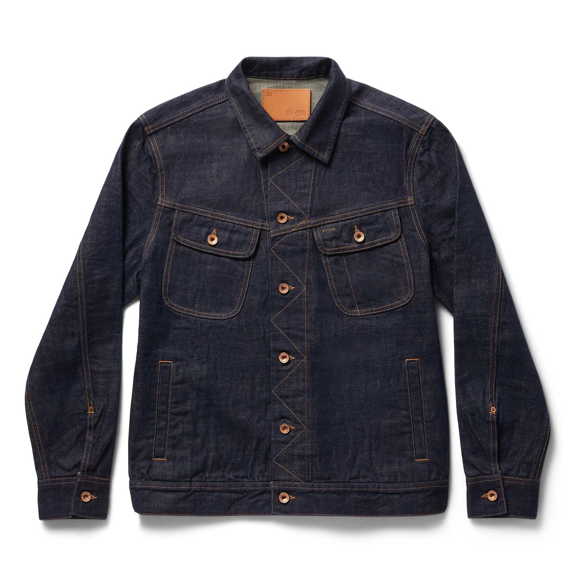 Front view of The Long Haul Jacket in Rinsed Organic Selvedge by Taylor Stitch, showing the dark indigo denim, dual chest pockets, copper buttons, and leather patch at the collar, on a white background