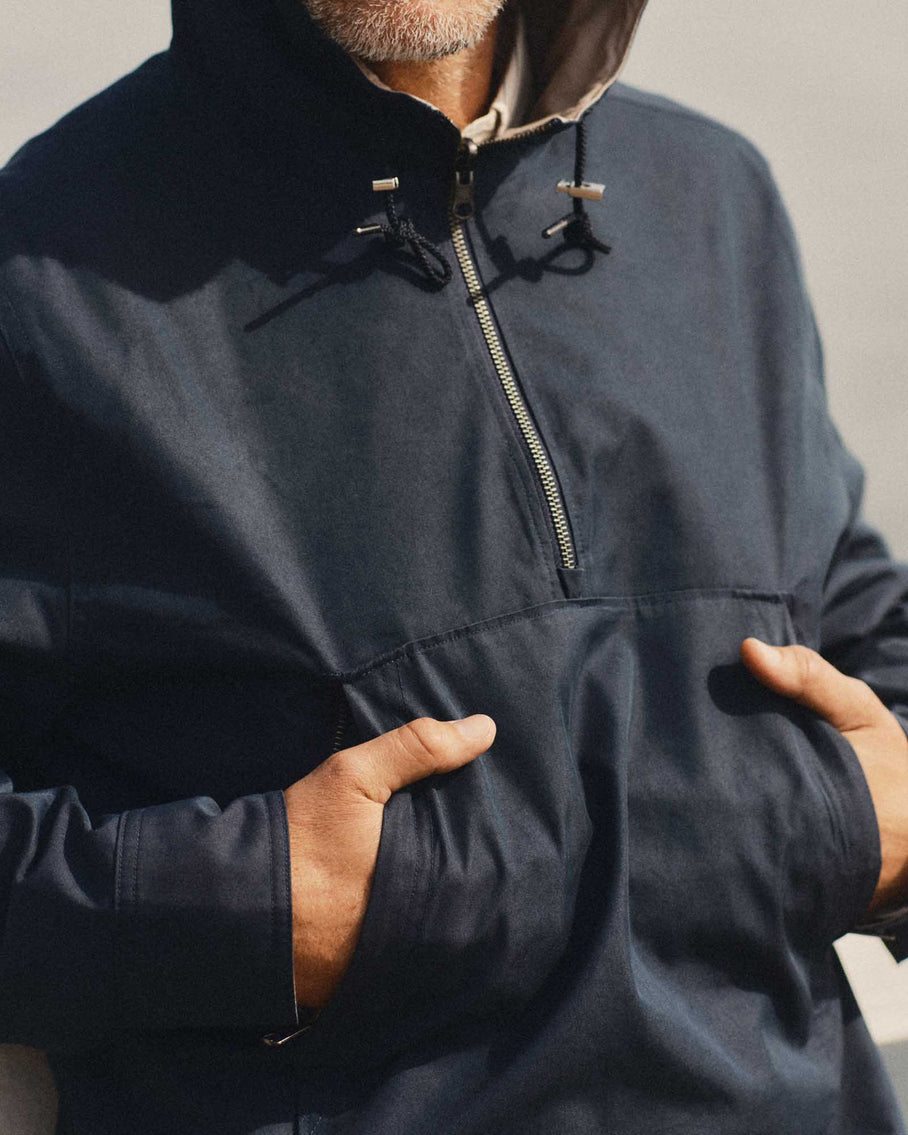 Close-up of chest/hood area showing YKK zip, drawcord toggles, kangaroo pocket, and twill fabric texture