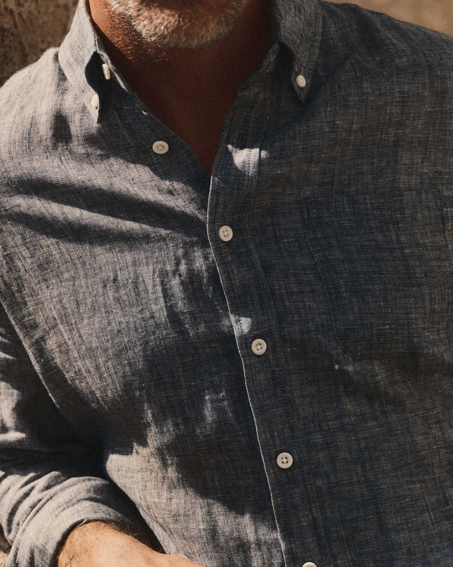 Close-up of Taylor Stitch The Jack in Ocean Linen showing button-down collar with lock-stitched buttons and ocean blue-grey washed European linen texture with double-needle felled seam construction detail
