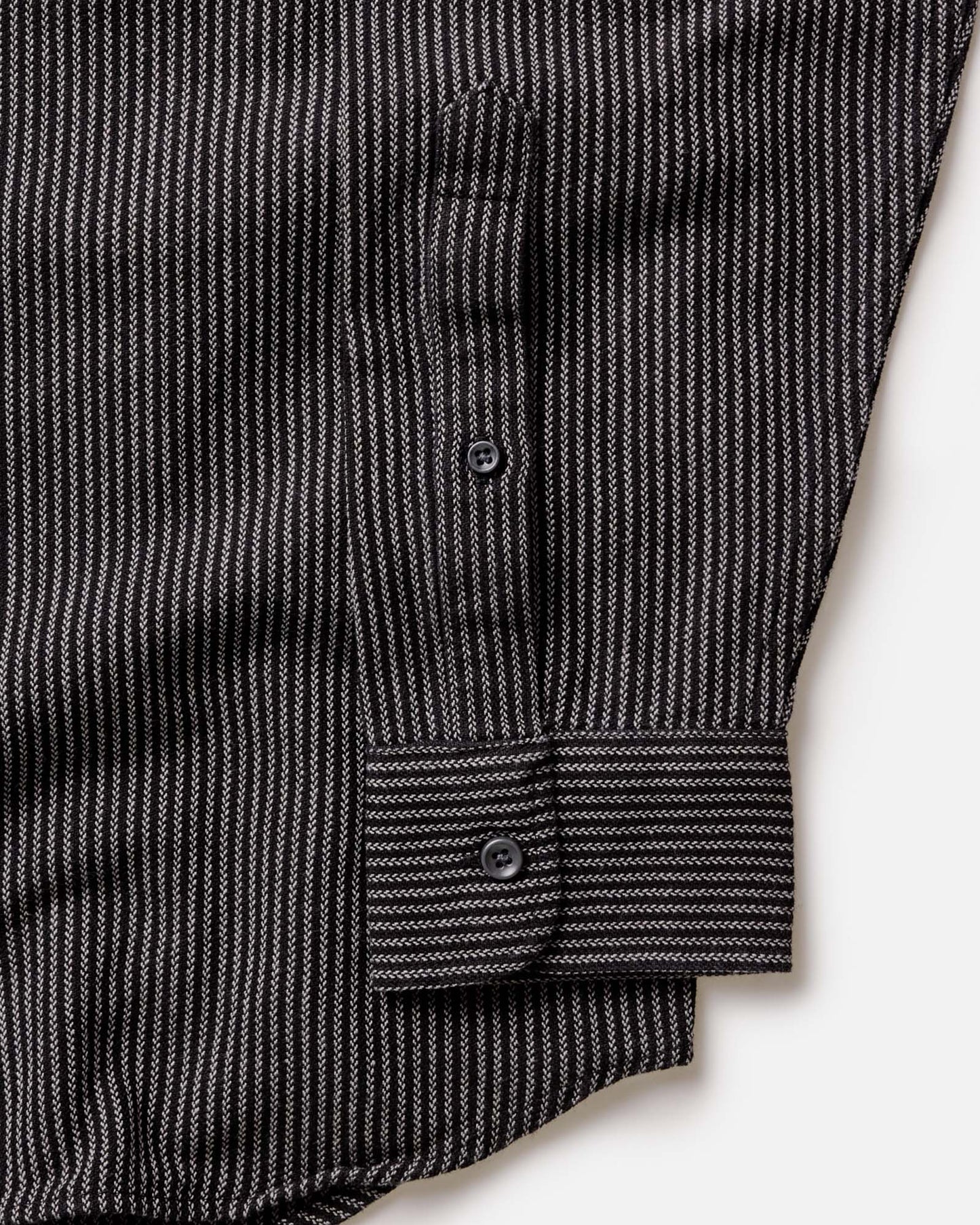 Close-up detail of The Jack in Roped Black Indigo showing roped indigo stripe fabric texture, button placket, and barrel cuff