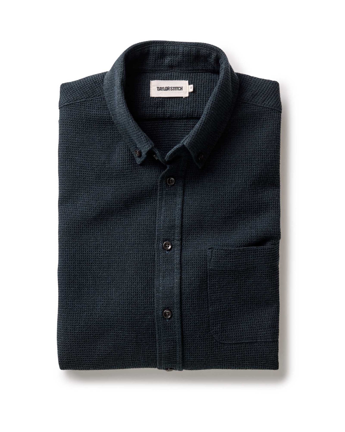 Taylor Stitch Jack Shirt in Forest Waffle, folded flat view showing dark forest green waffle texture, button-down collar, and Taylor Stitch label on white background