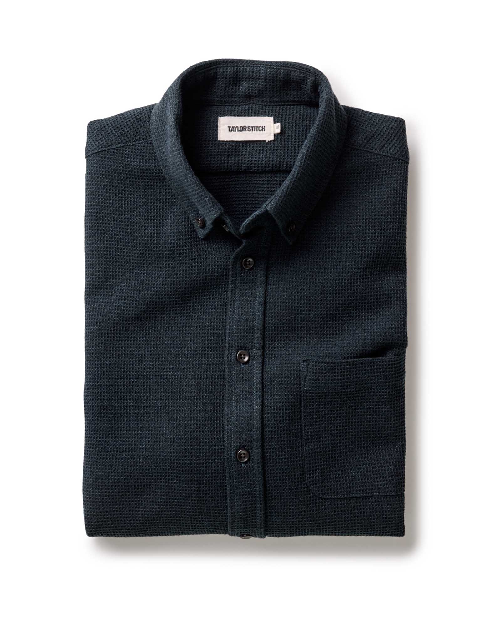 Taylor Stitch Jack Shirt in Forest Waffle, folded flat view showing dark forest green waffle texture, button-down collar, and Taylor Stitch label on white background