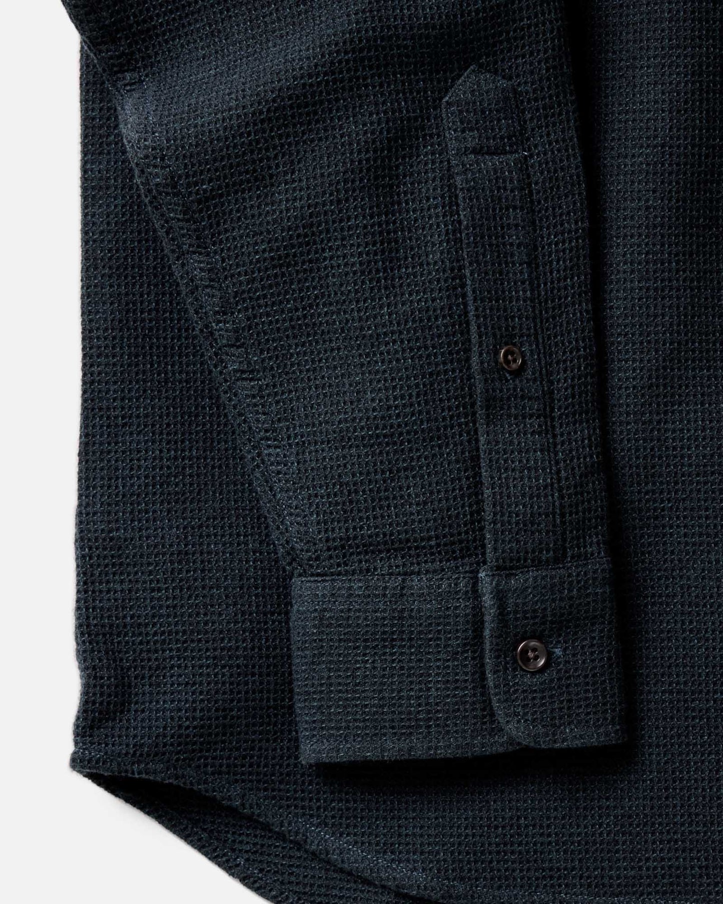 Close-up detail of the Taylor Stitch Jack Shirt in Forest Waffle showing sleeve cuff, lock-stitched buttons, and organic cotton waffle weave texture in dark forest green
