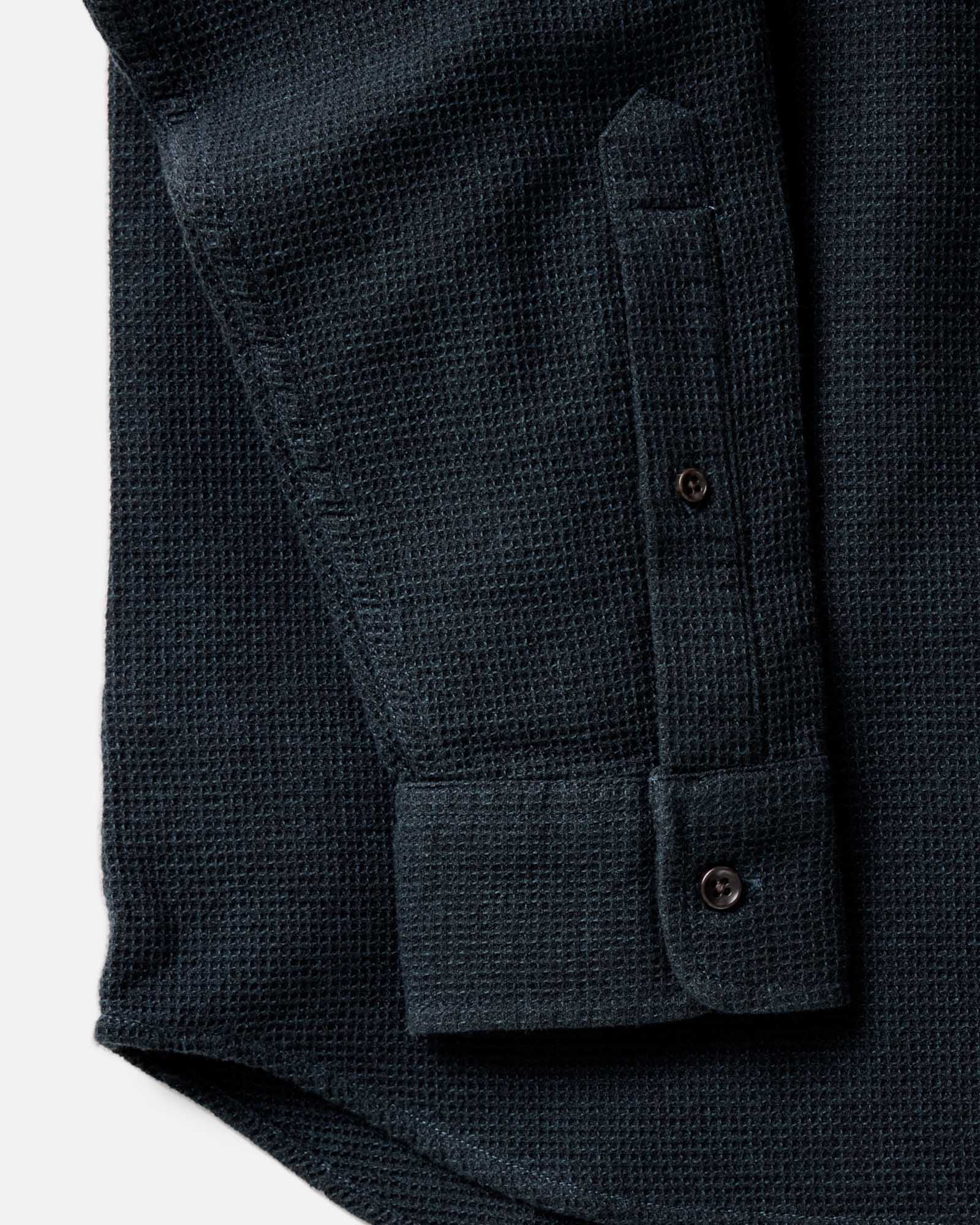 Close-up detail of the Taylor Stitch Jack Shirt in Forest Waffle showing sleeve cuff, lock-stitched buttons, and organic cotton waffle weave texture in dark forest green