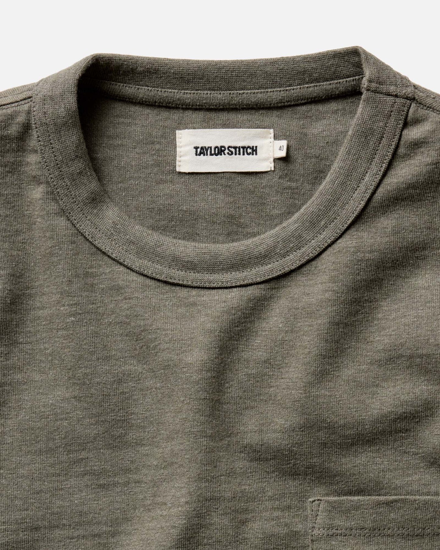 Close-up of the crew neck and Taylor Stitch label on The Long Sleeve Shop Tee in Army Twist, showing the 1x1 ribbed collar and army twist cotton texture