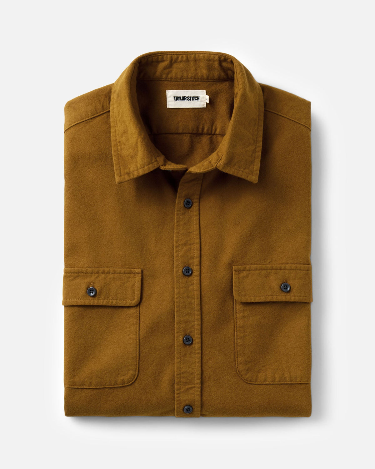 Taylor Stitch’s Yosemite Shirt in Saffron folded to show the collar, label, dark buttons, and two flap chest pockets.
