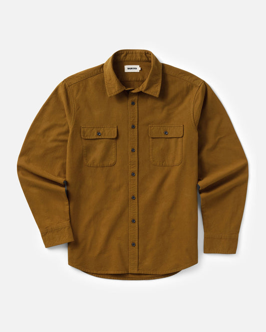 Flat lay view of Taylor Stitch’s Yosemite Shirt in Saffron, showing long sleeves, a button front, two flap chest pockets, and a curved hem.
