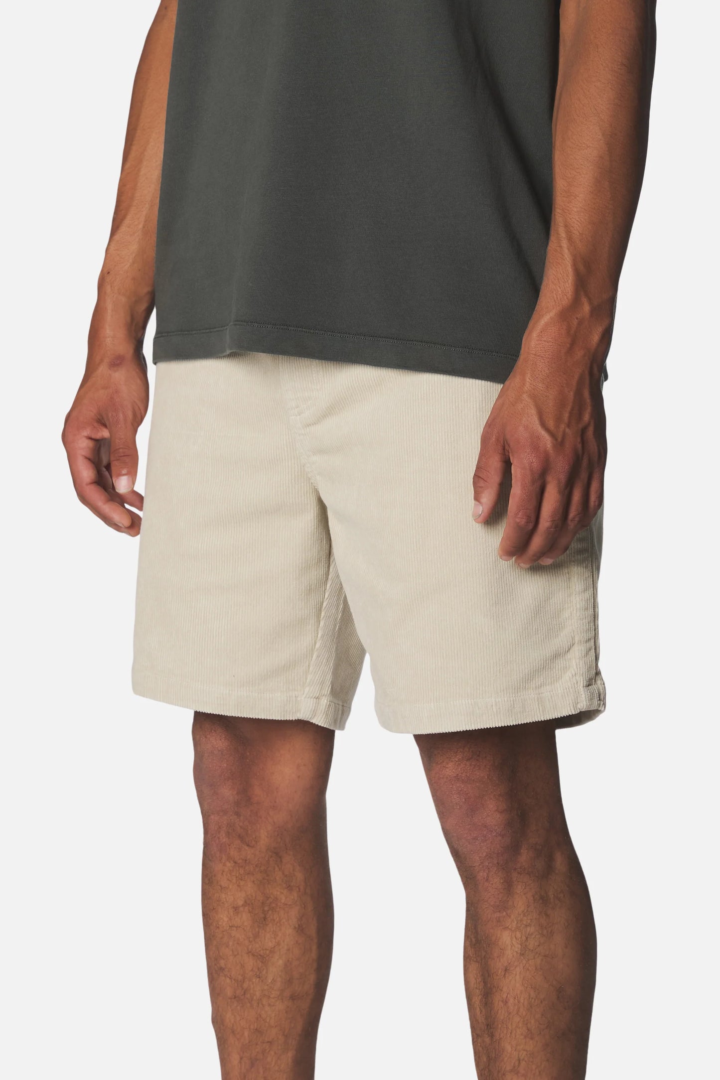 Katin Kord Patio Shorts in Pelican — side on-model view showing the ribbed corduroy texture, front slash pocket, and relaxed silhouette in pelican cream, worn with a dark grey t-shirt on a white background
