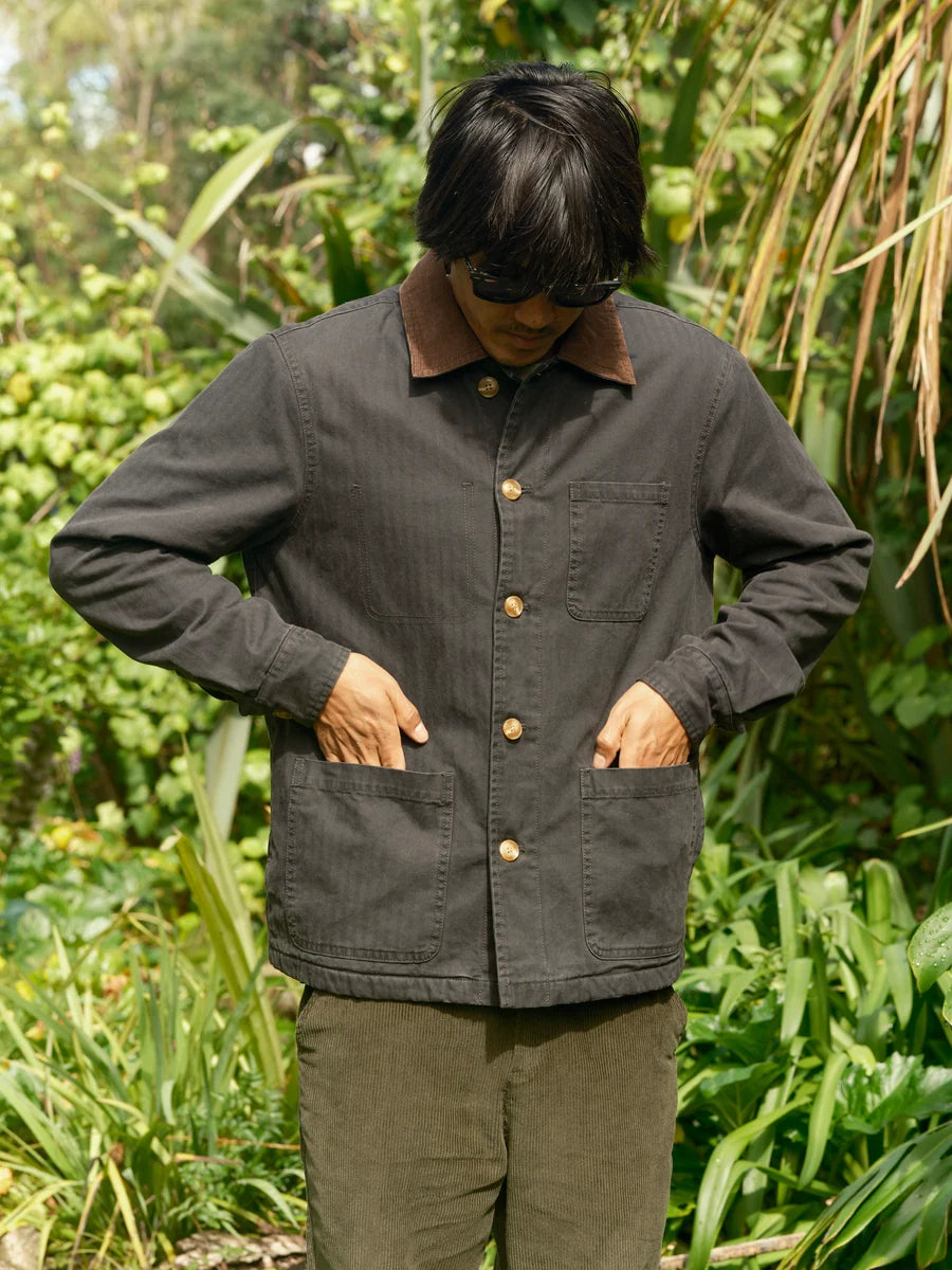 Model wearing the navy Lined Builder Jacket buttoned, with hands in the lower front patch pockets.
