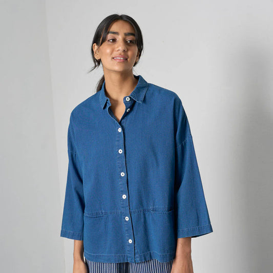 Woman wearing a blue shirt with a plain background