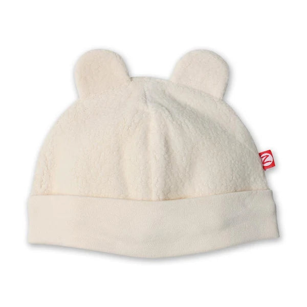 Zutano Cream fleece baby hat with two rounded bear ears, a wide folded band and a small red brand tag.
