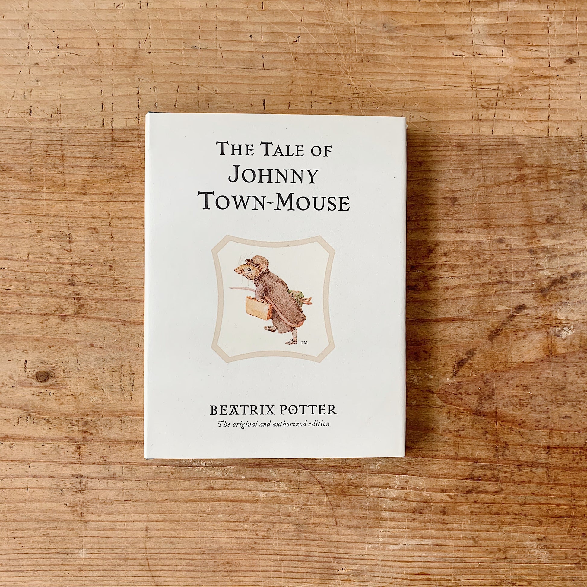 The children's book 'The tale of johnny town mouse' shown on a wooden background