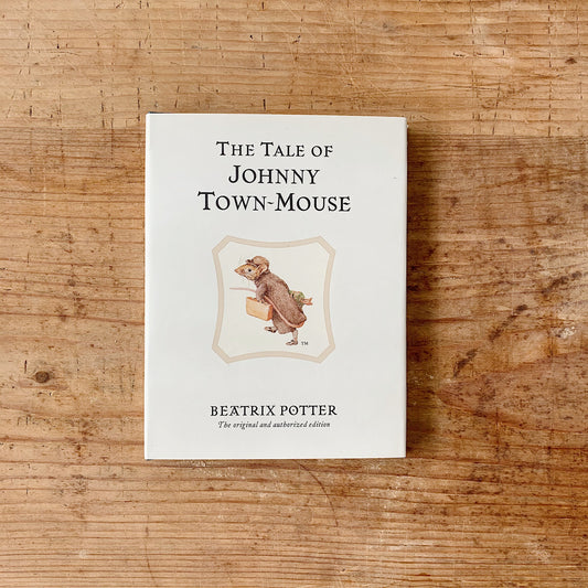 The children's book 'The tale of johnny town mouse' shown on a wooden background