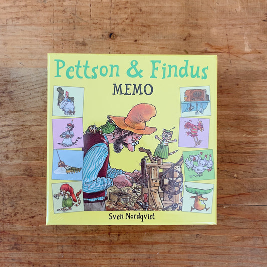 Yellow-green Pettson and Findus Memo game box by Sven Nordqvist, showing Pettson working on a wooden invention beside Findus, with illustrated matching cards around the edges.
