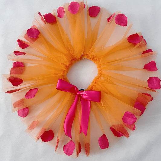 An orange tutu with fuchsia petal accents and a fuchsia ribbon bow at the waist.