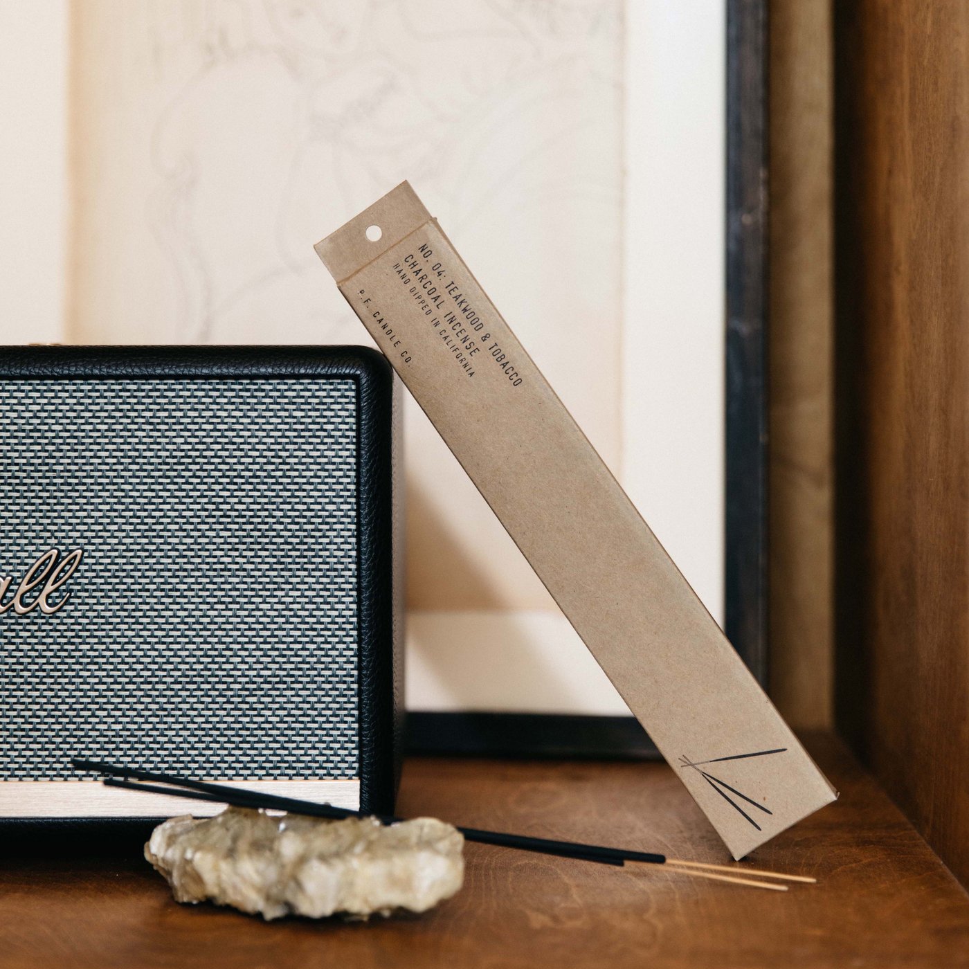 The teakwood and tobacco package leaning against a piece of stereo equipment.