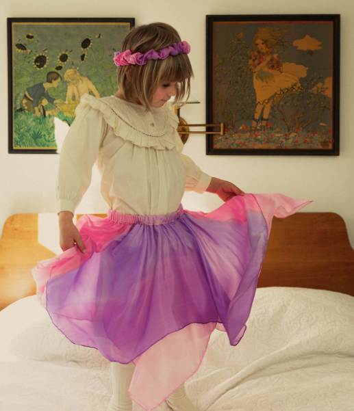 sarah's silks front view playskirt in blossom seen on model twirling on bed
