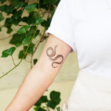 Load image into Gallery viewer, tattly serpent tattoo seen on model&#39;s inner upper arm
